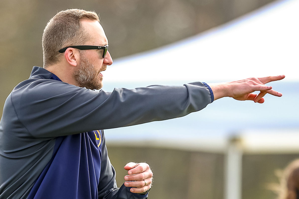 Soccer coach pointing at the field of play